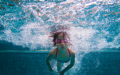 Une fille nage sous l'eau dans une piscine