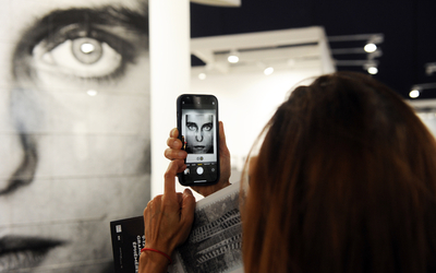 Personne prenant en photo une photographie portrait prise par l'artiste japonais Ken Ohara - Paris Photo 2023 au Grand Palais Ephémère. Galerie Miyako Yoshinaga. 
