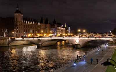 Vue des quais avec des cyclistes et de la Conciergerie de nuit