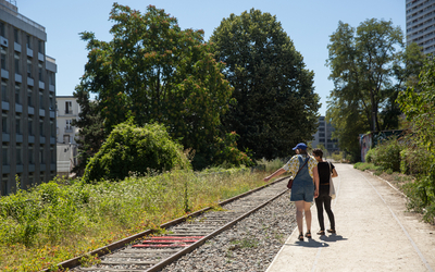 Deux personnes se promenent le long de la Petite Ceinture.  