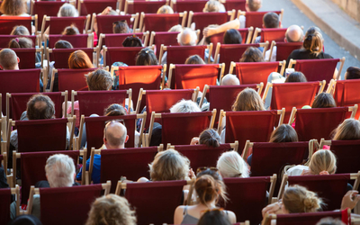 Personnes installées sur transat en plein air pour regarder un film