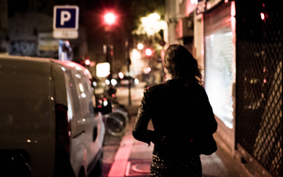 Une femme marche dans les rues, seule la nuit. 