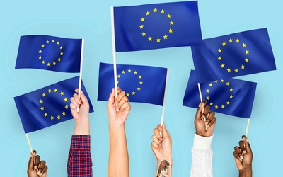 Des mains qui tiennent des drapeaux européens